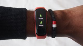A Samsung Galaxy Fit 2 displaying a workout screen, worn on someone's wrist