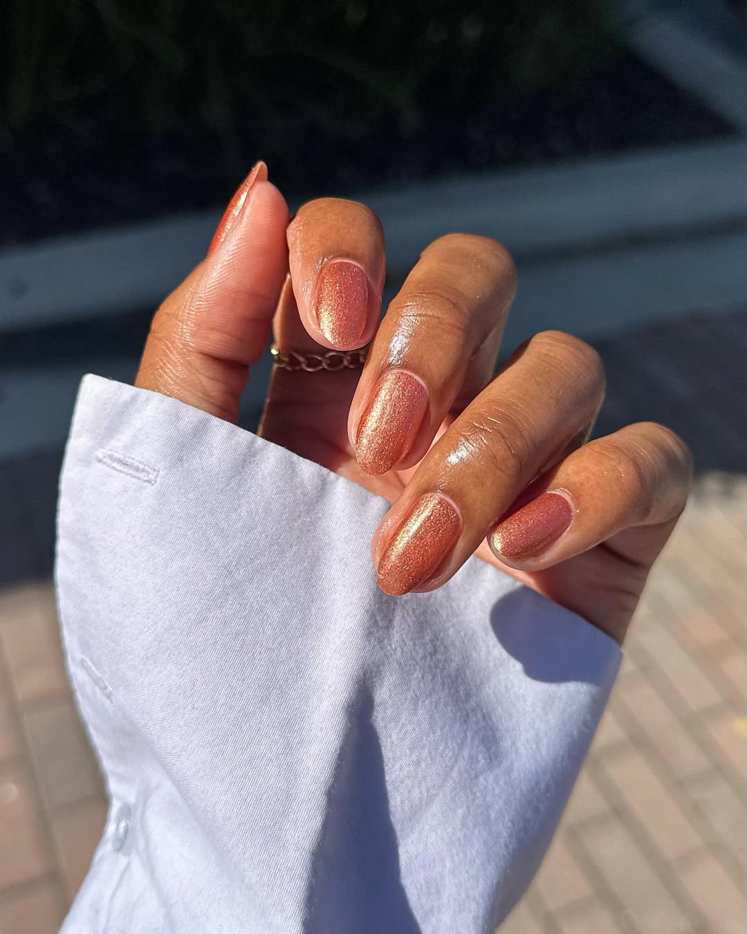 a person wearing a copper nail polish color