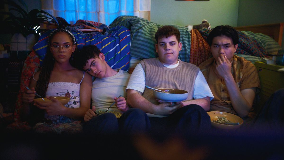 Elle, Charlie, Isaac and Tao sit on the bedroom floor eating pasta