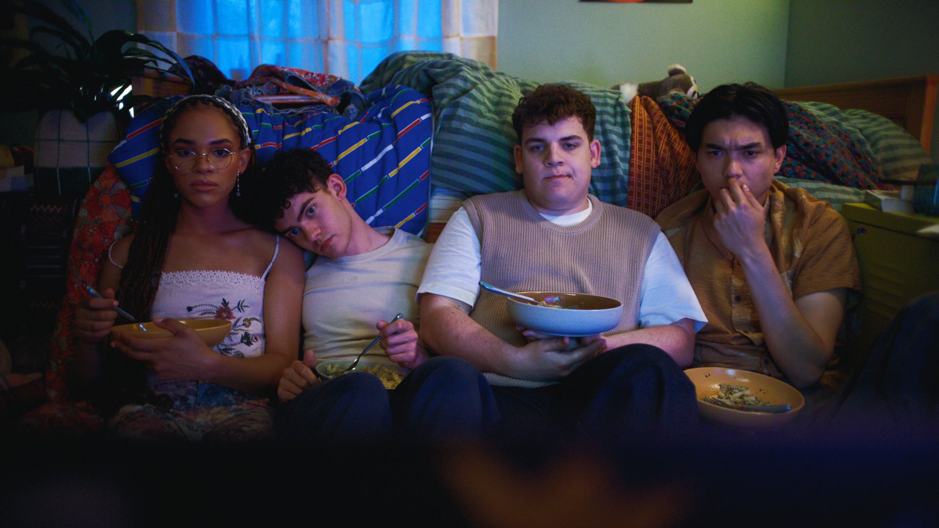 Elle, Charlie, Isaac and Tao sit on the bedroom floor eating pasta