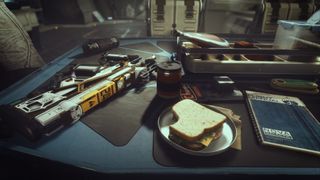 A work desk in Starfield, with a half-eaten sandwich and a weapon laying on it