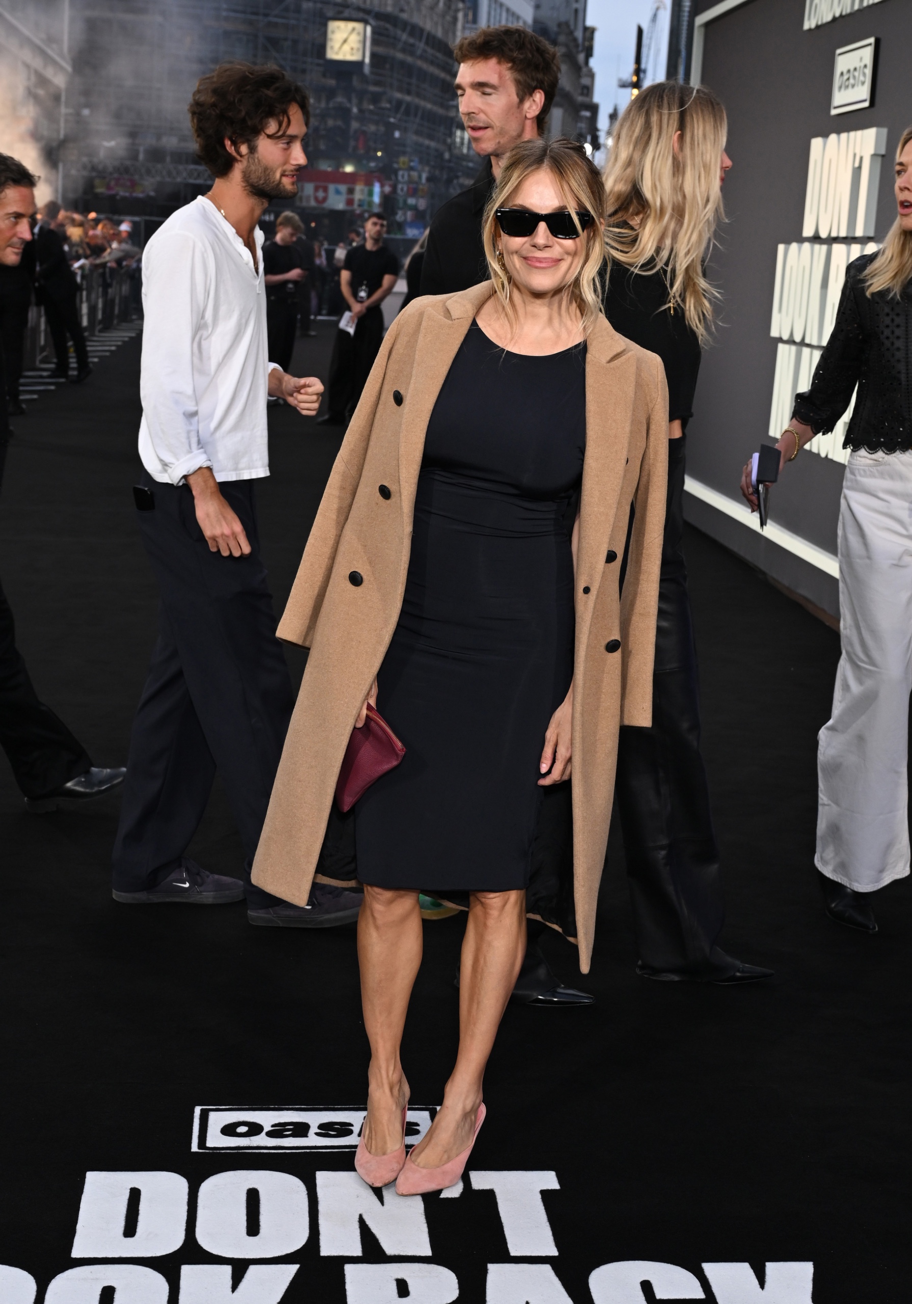 Sienna Miller on the red carpet wearing a camel coat