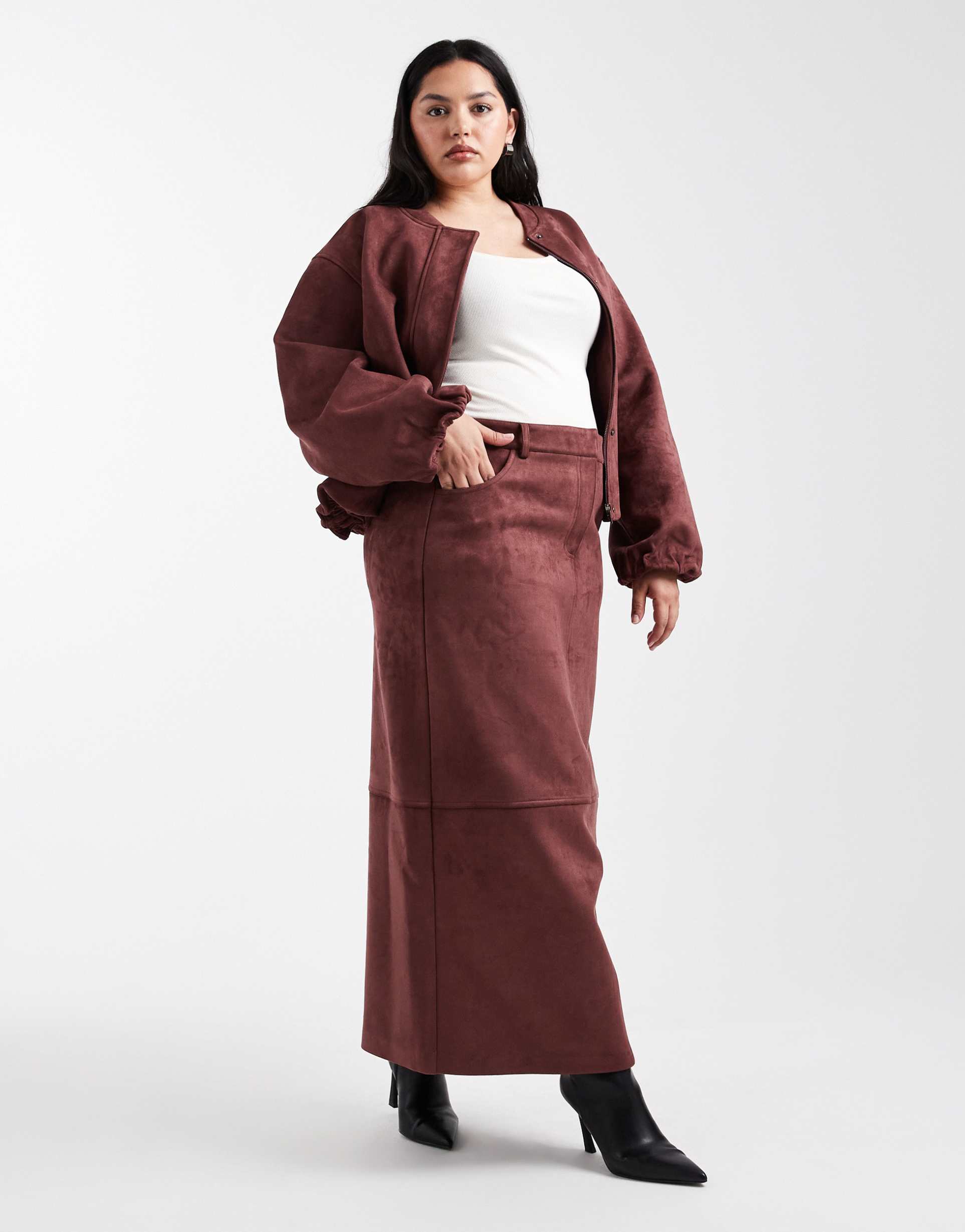 A model wearing a burgundy maxi suede skirt.