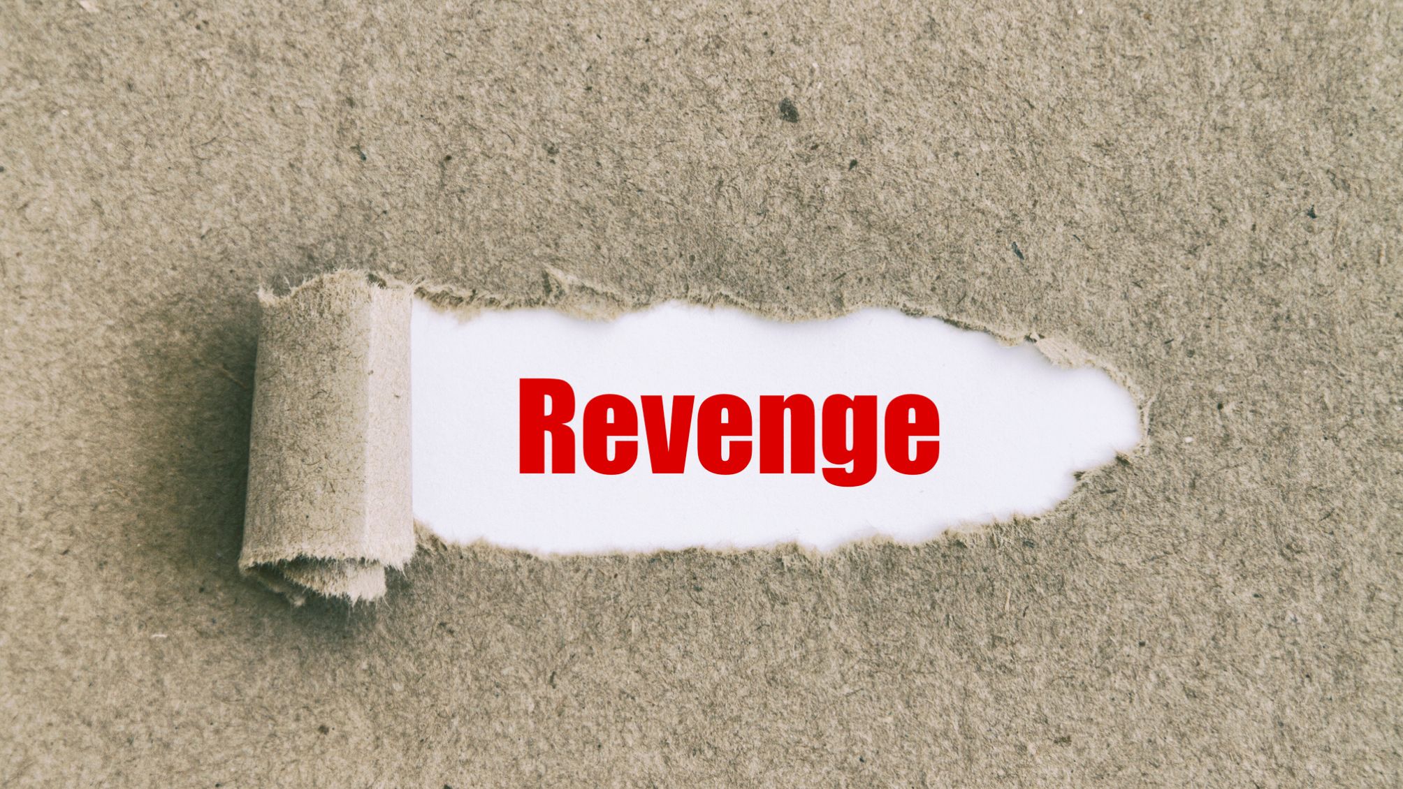 The word revenge revealed through torn paper. 