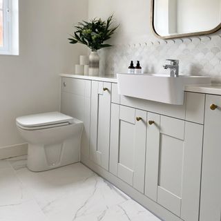 neutral en suite bathroom with cabinets and sink and loo