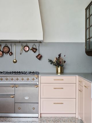 pastel pink kitchen cabinets in front of a grey wall