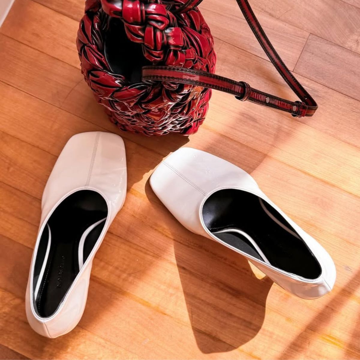 a pair of white square toe heels