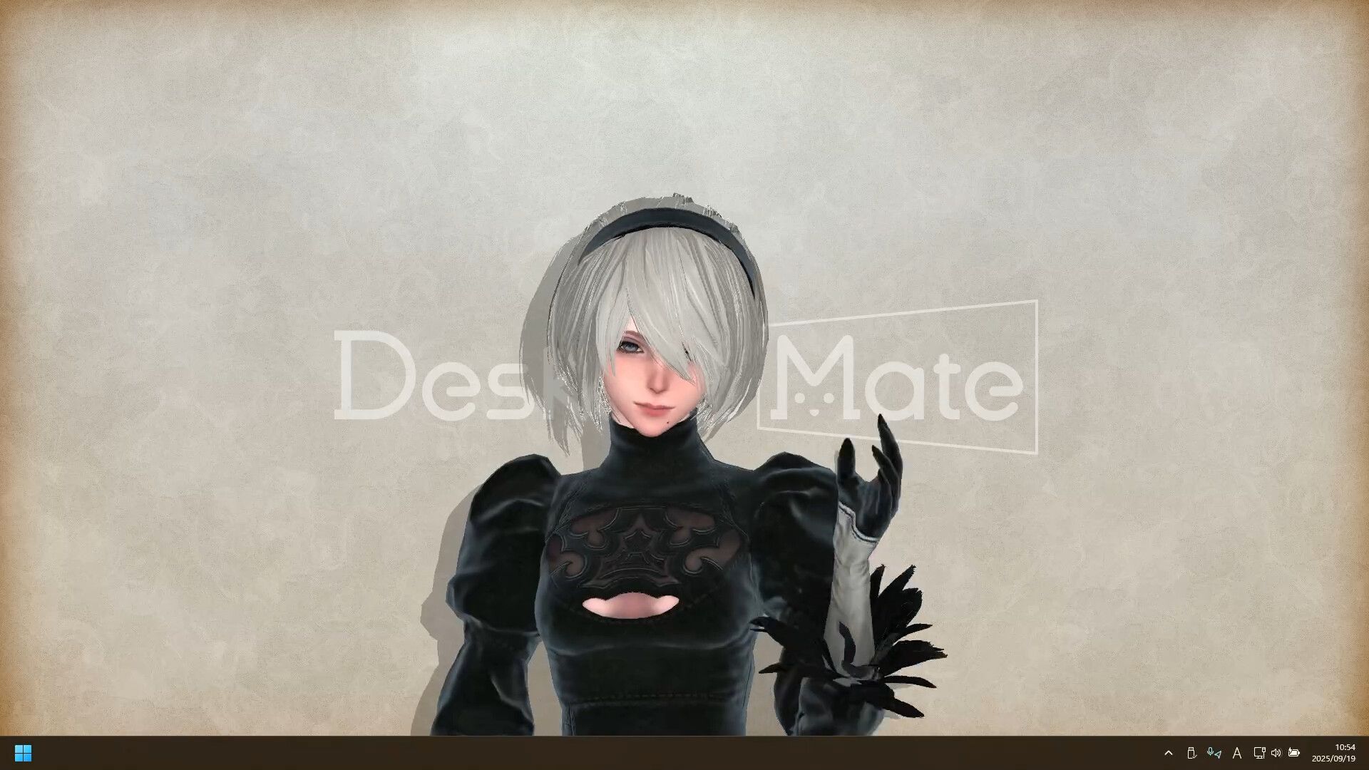Nier Automata&#039;s 2B smiles into the camera while standing in front of a plain cream screen and the Desktop Mate logo.