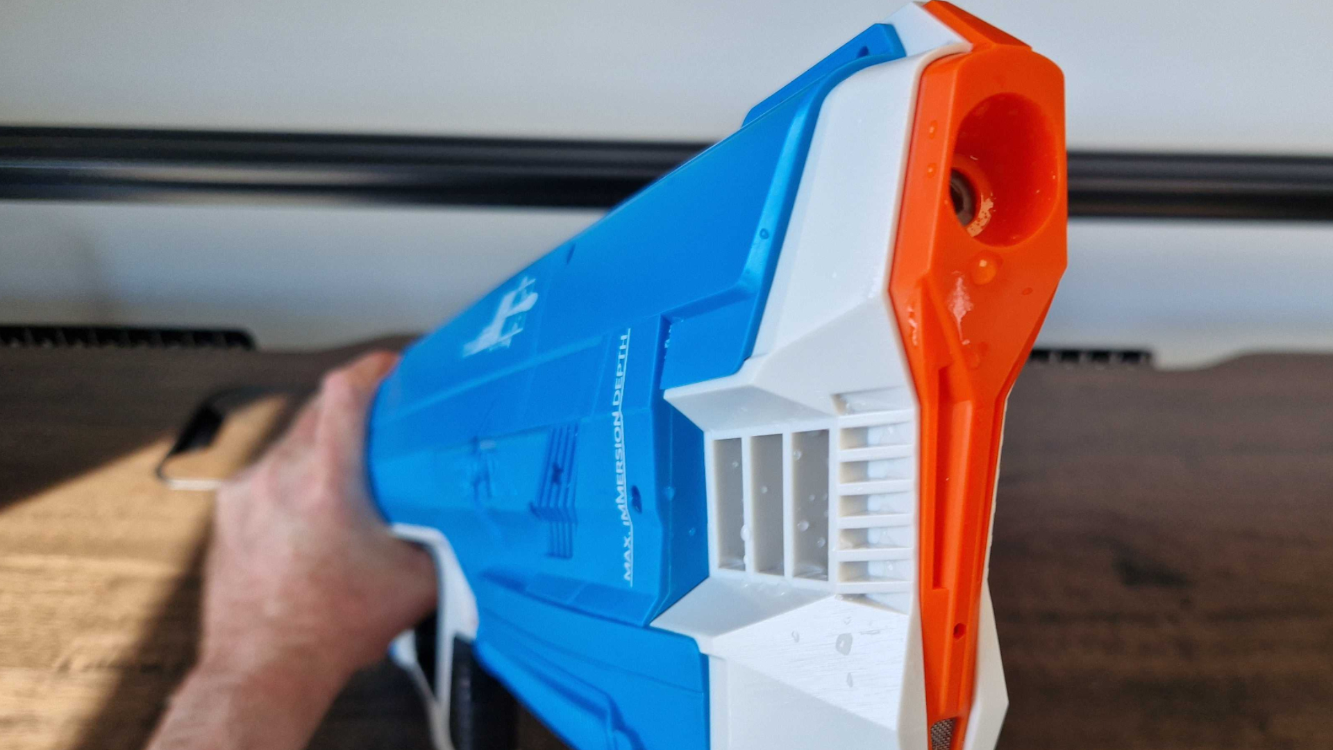 A hand holding the SpyraThree blaster, front-forward