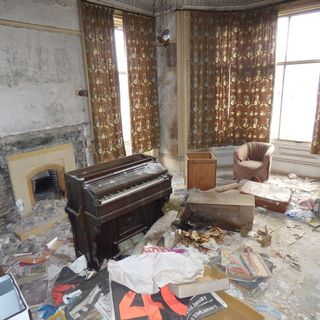 living room with piano and fireplace