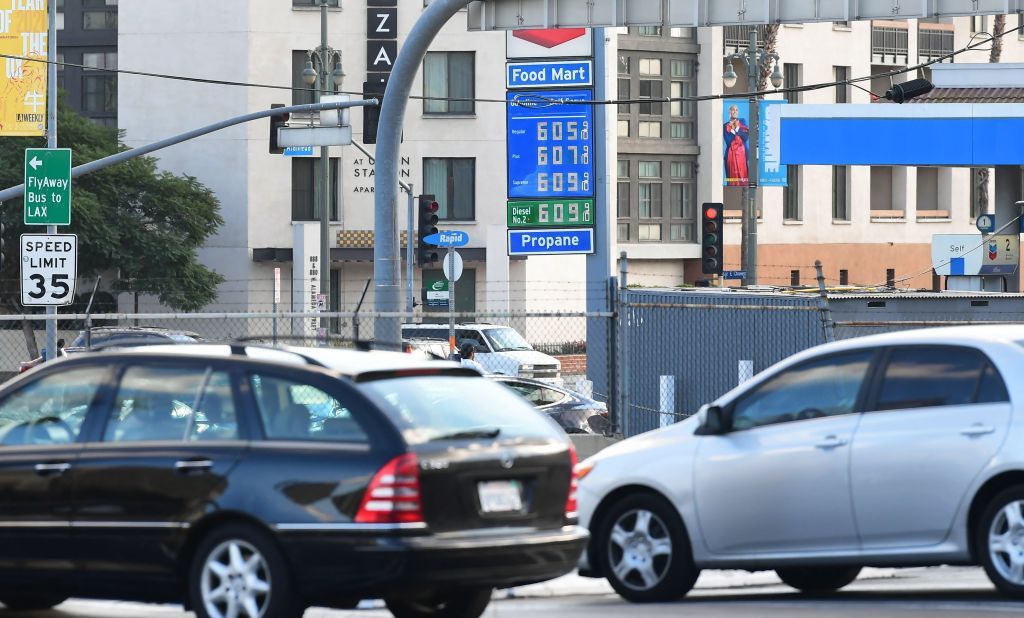 Cars driving past gas station.