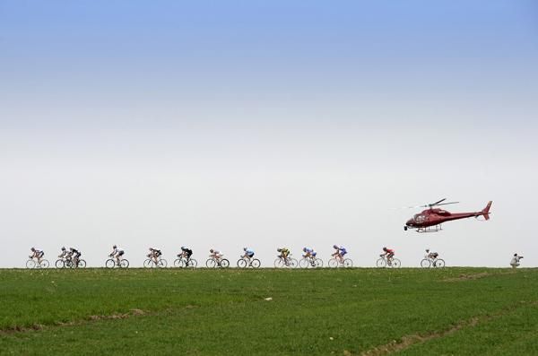 A helicopter chases the peloton through Flanders.