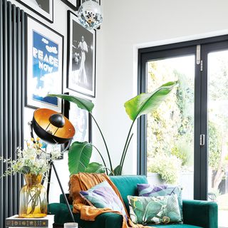 White living room with gallery wall behind green velvet armchair
