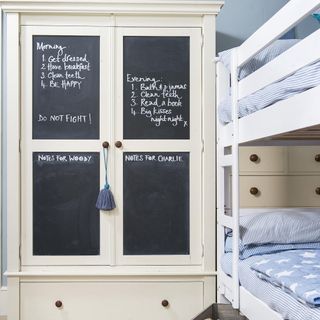 kids room with bunk bed and blackboard on wardrobe
