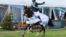 Image shows Imogen King riding a bay horse, who is wearing a winner's rug, on a lap of honour at Osberton.