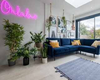 A living room corner idea by Snug with pink neon Ooh La La sign and small L-shaped sofa that came in a box
