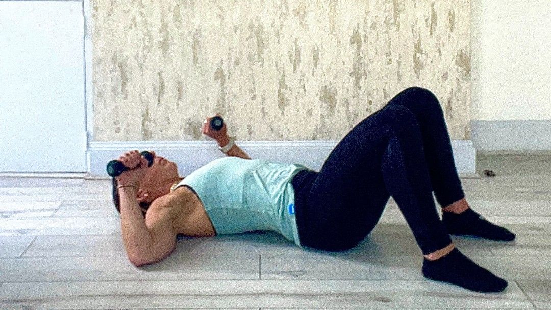 Lucy Miller performing glute bridge and dumbbell press at home