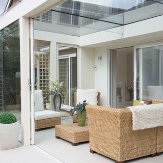 Glass box extension with wicker sofa, chairs and coffee table