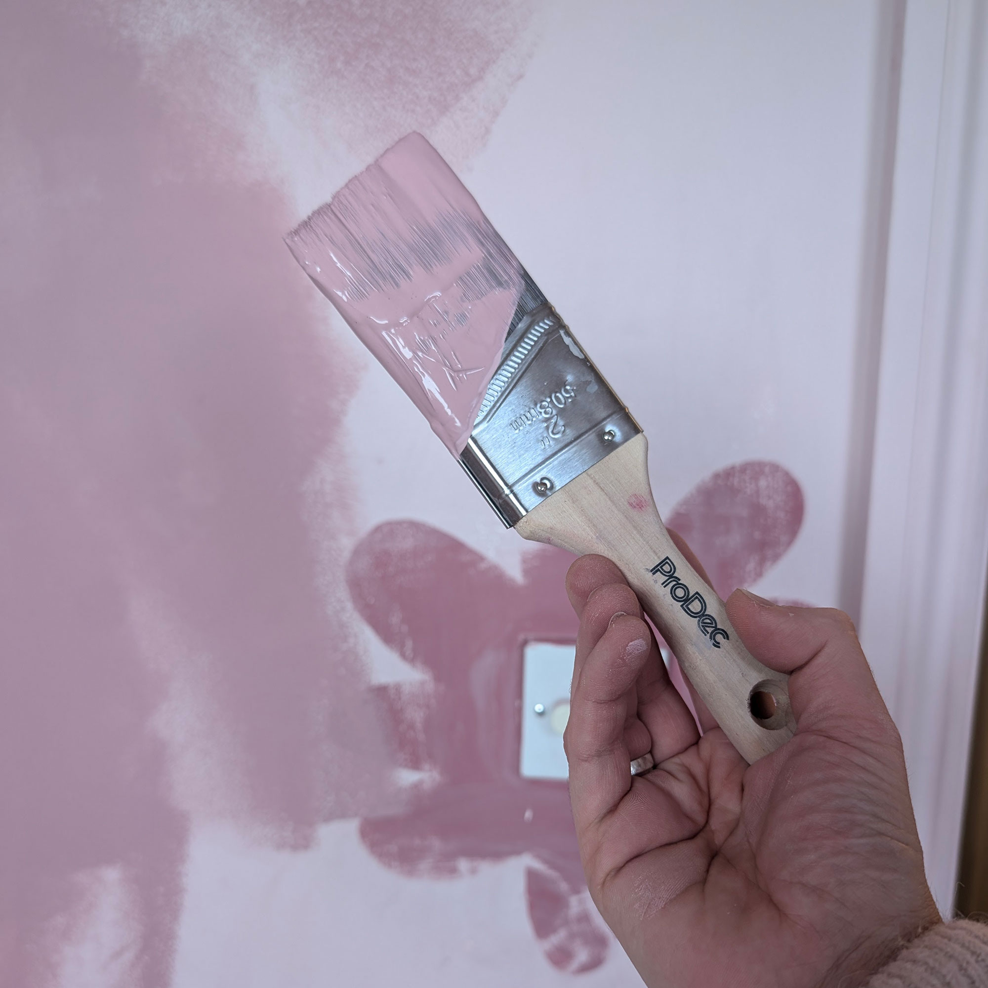 Pink paint on wall and brush