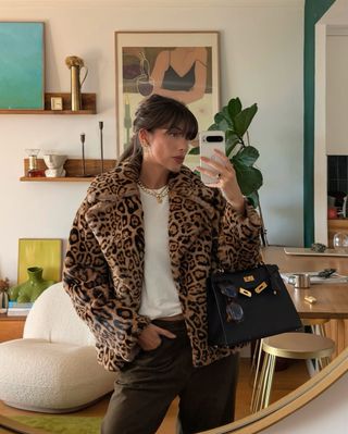 @juliesfi wearing a leopard print coat with jeans