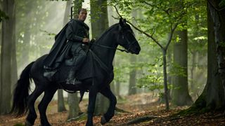 Lan rides his horse through a forest in The Wheel of Time season 2