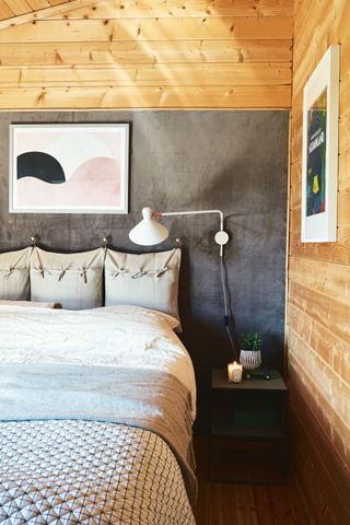 wooden and gray bedroom with cushion headboard and dark floor