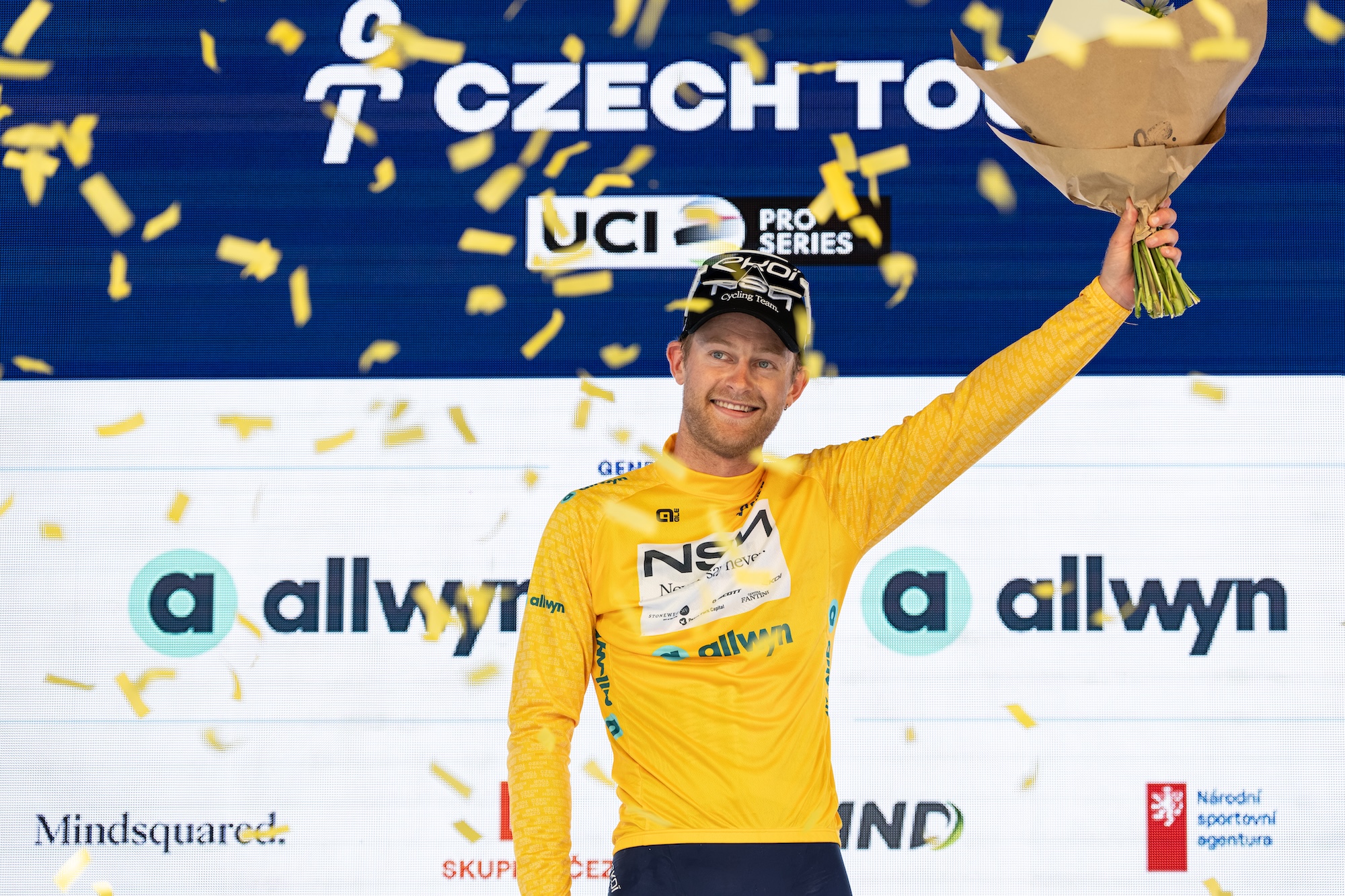 Riley Sheehan of Team NSN celebrates on the podium in the yellow jersey as overall leader after stage 1 of the Czech Tour 2026
