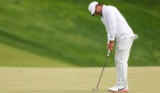 Brooks Koepka hits a putt on the green
