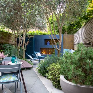 garden with blue painted wall and fireplace table and chairs