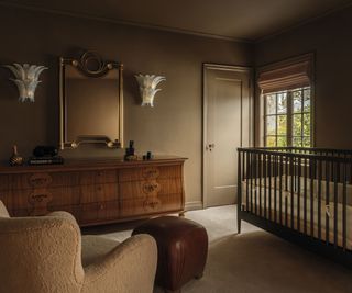 corner of room with dark walls and sideboard and crib