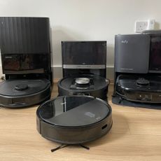 Four robot vacuums standing next to each other on wood-effect flooring