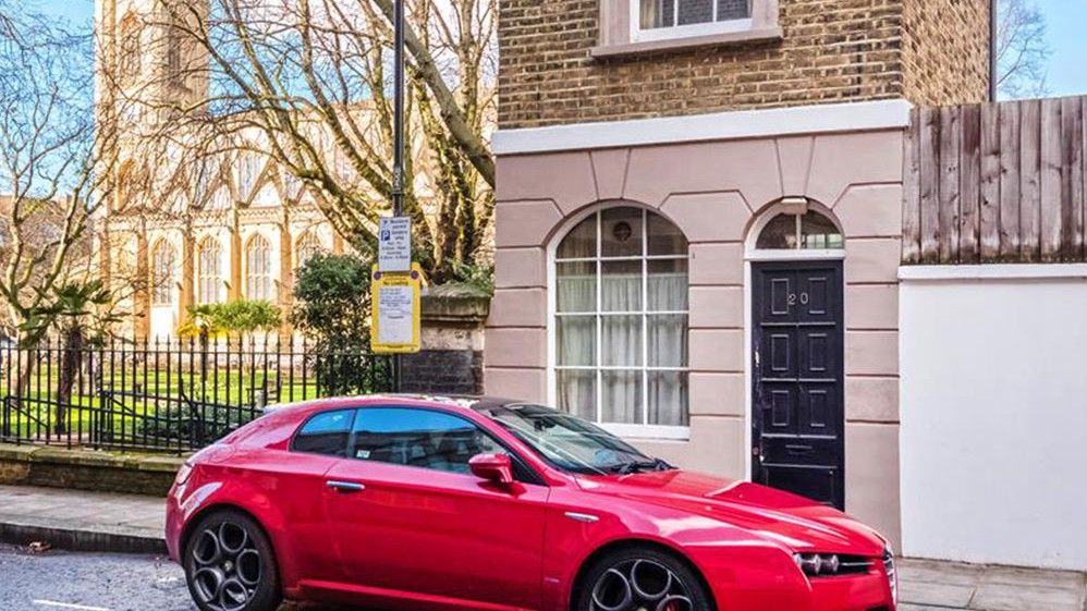 two story apartment with white window and car