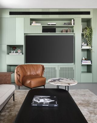 A living room with a green painted TV unit