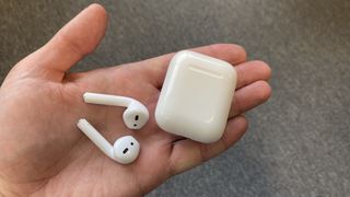 AirPods and charging case on a man's hand