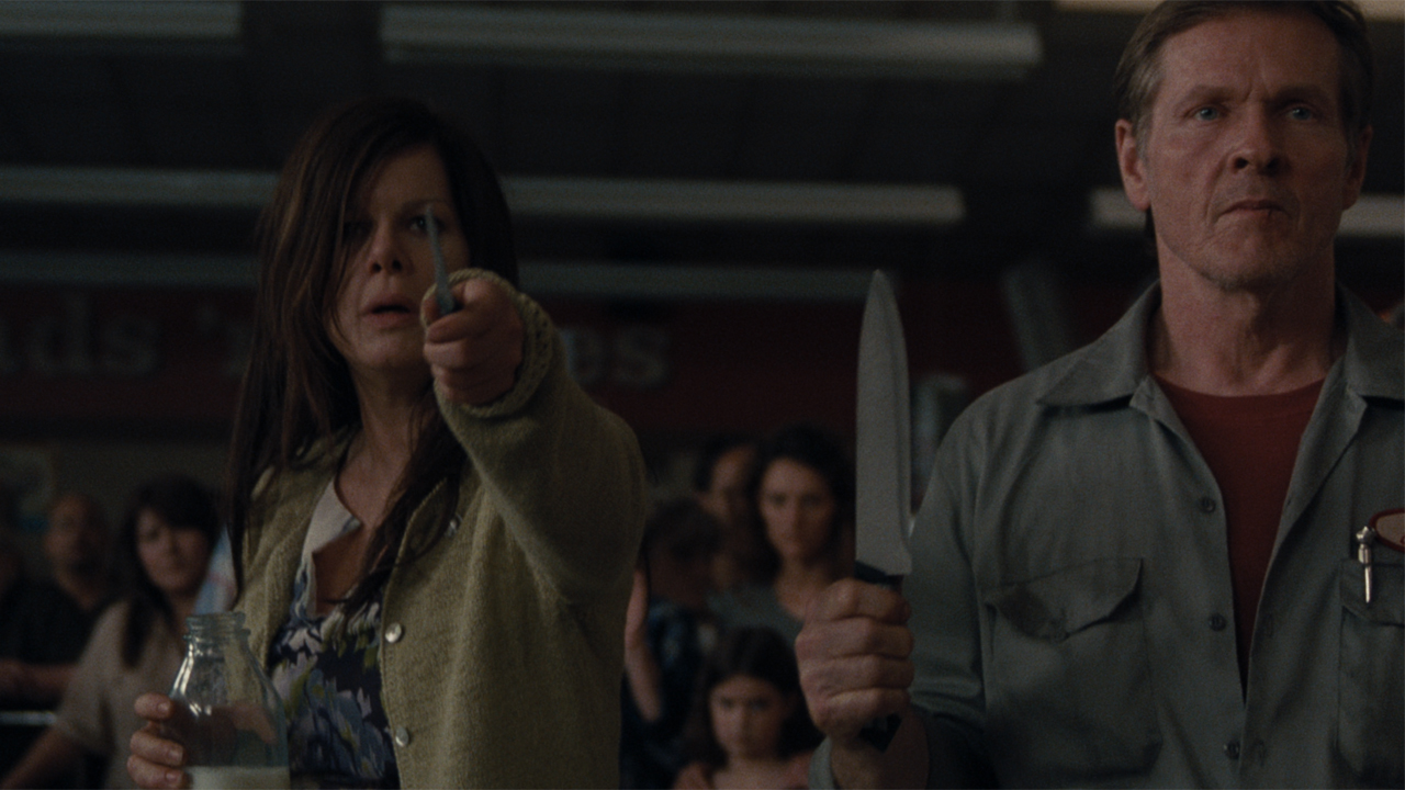 Ms Carmody holding a knife in The Mist