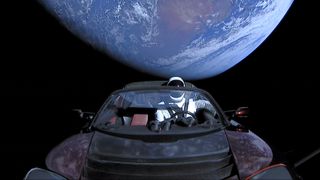 A photo of a Tesla floating in space with a spacesuit-clas mannequin in the driver's seat 