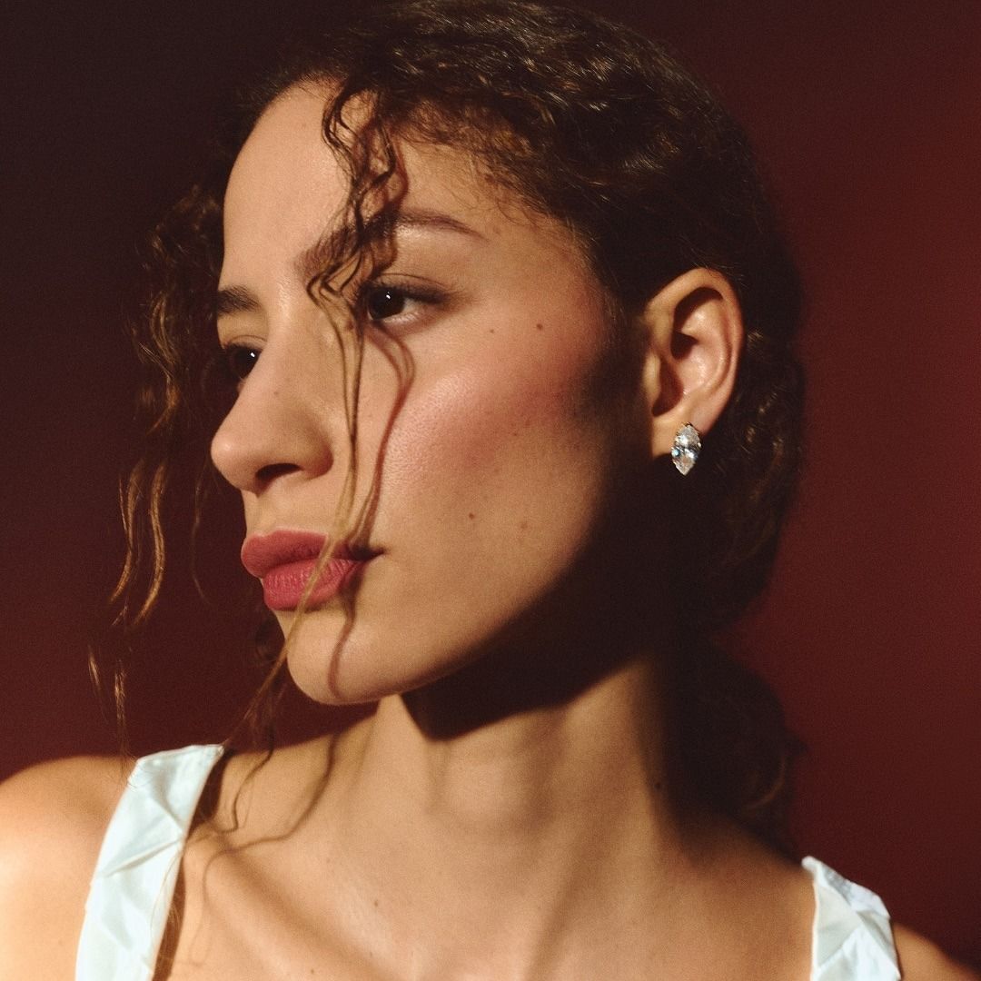 Photo of model wearing diamond stud earrings.