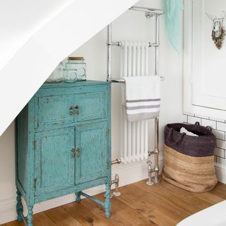 bathroom with blue vintage cupboard and wooden flooring