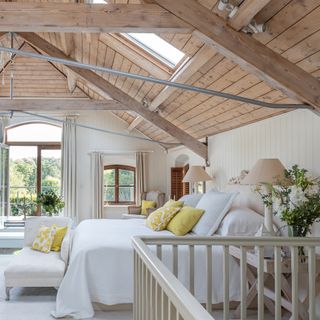 large bedroom with wood clad vaulted ceiling and french doors to balcony