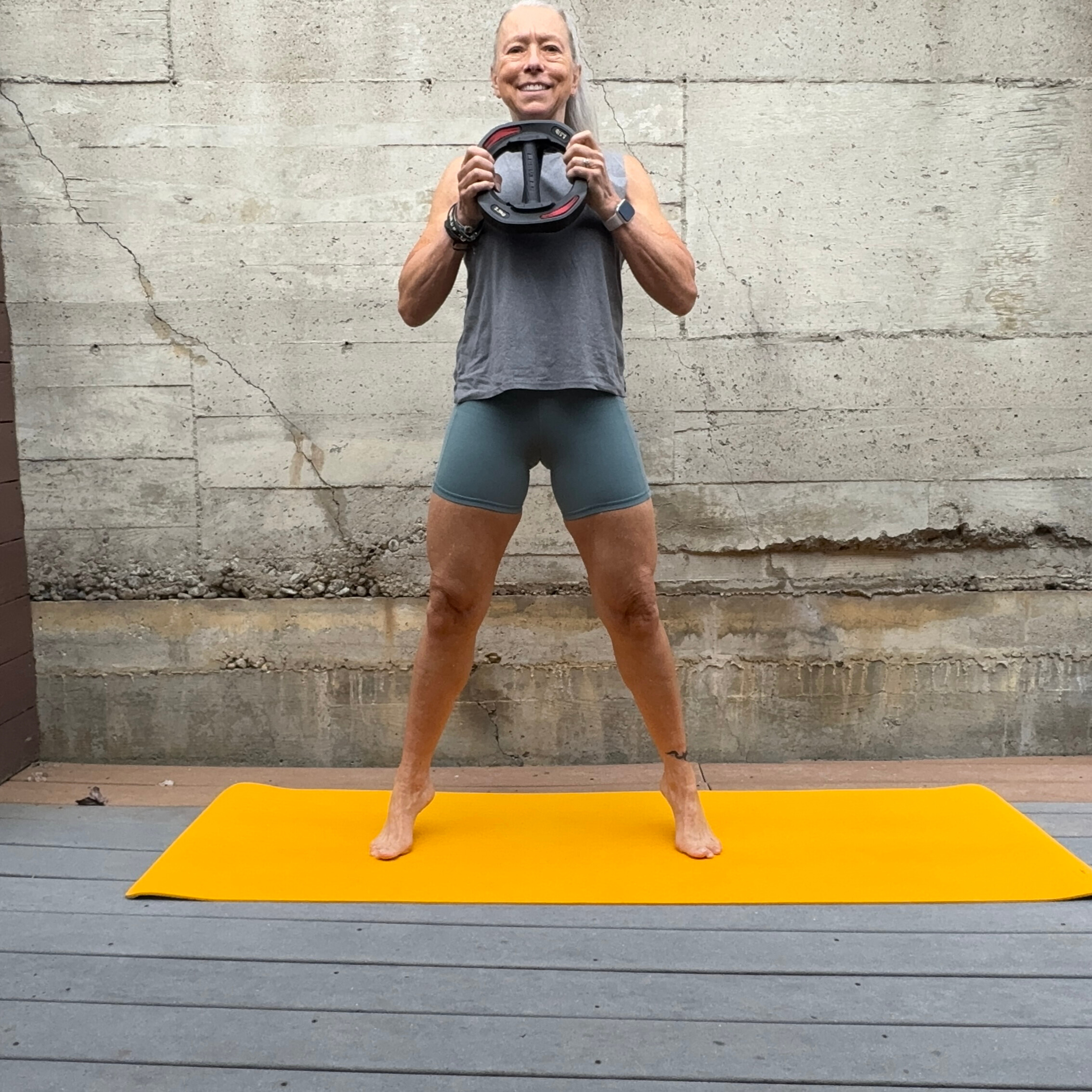 Woman exercising with weight plate