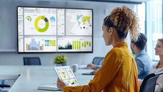 A woman uses Philips ScreenShare in a corporate setting at her meeting room.