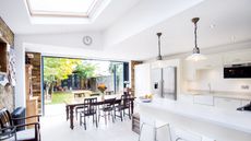 a white and bright kitchen extension opening to the garden