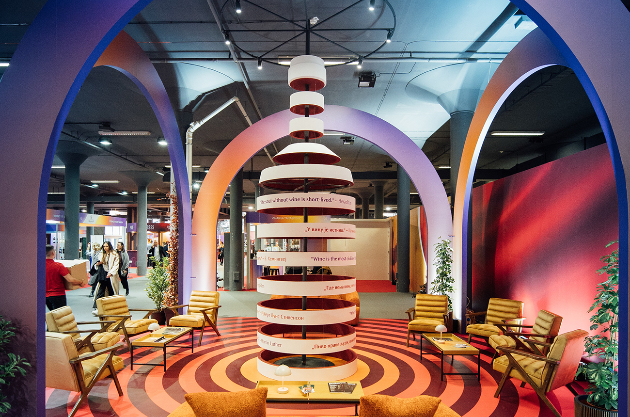Large spiral wooden statue of a wine bottle in colourful surroundings