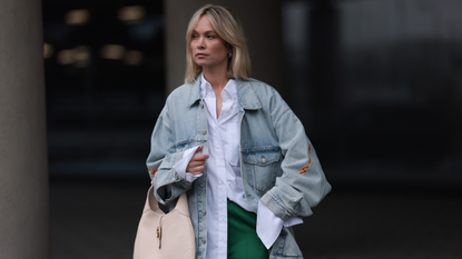Nadine Berneis seen wearing Balenciaga light blue oversized logo denim / jeans jacket, Black Palms The Label white cotton oversized buttoned shirt, Karo Kaur Label green / white wide leg pants, Gucci beige / creamy white leather bag, on March 06, 2024 in Munich, Germany. (Photo by Jeremy Moeller/Getty Images)