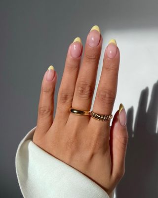 A french manicure with lemon tips by Iram Shelton