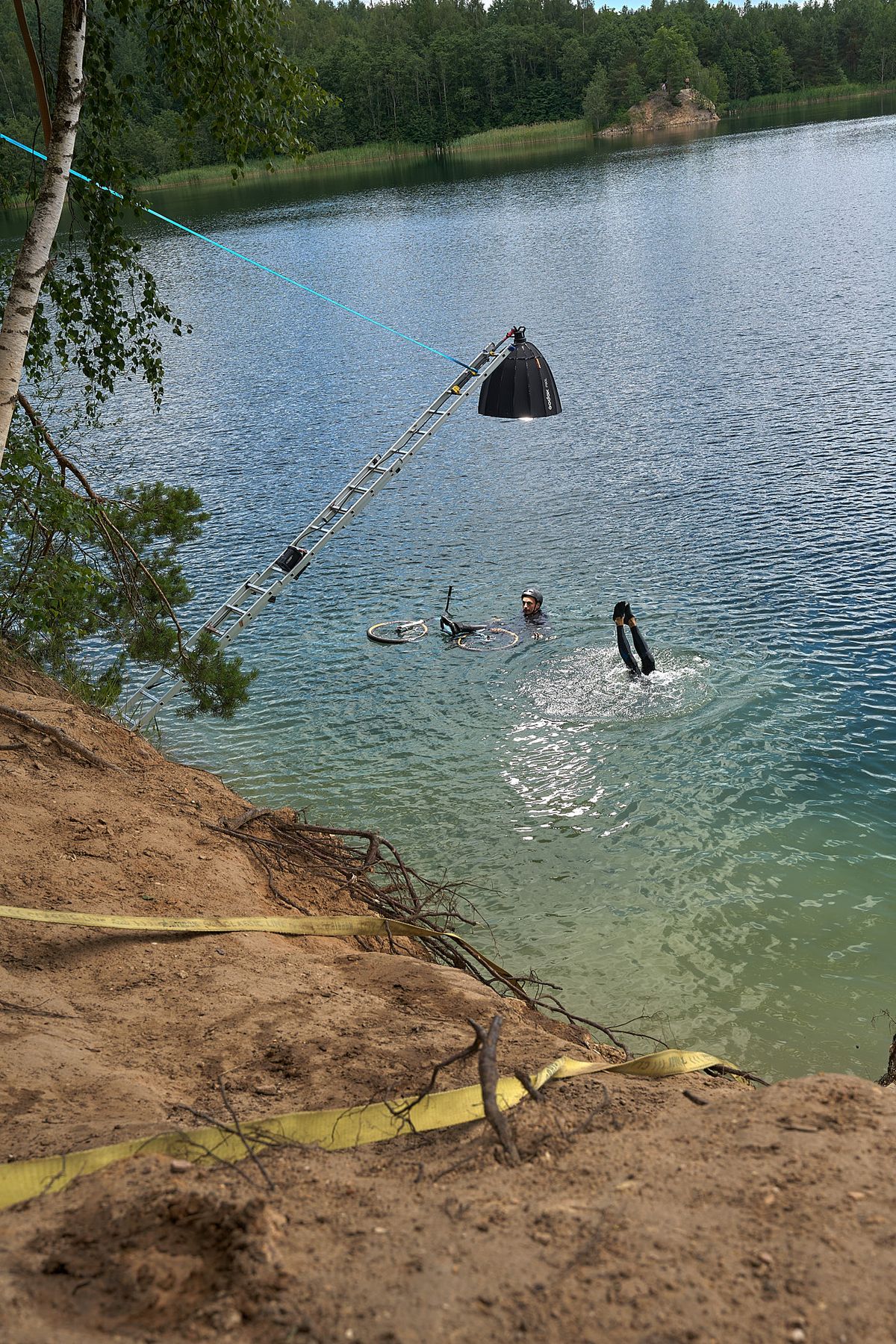 A behind-the-scenes photo of how Volodya Voronin captured the BMX in water shot using a ladder, a rope, and a flash