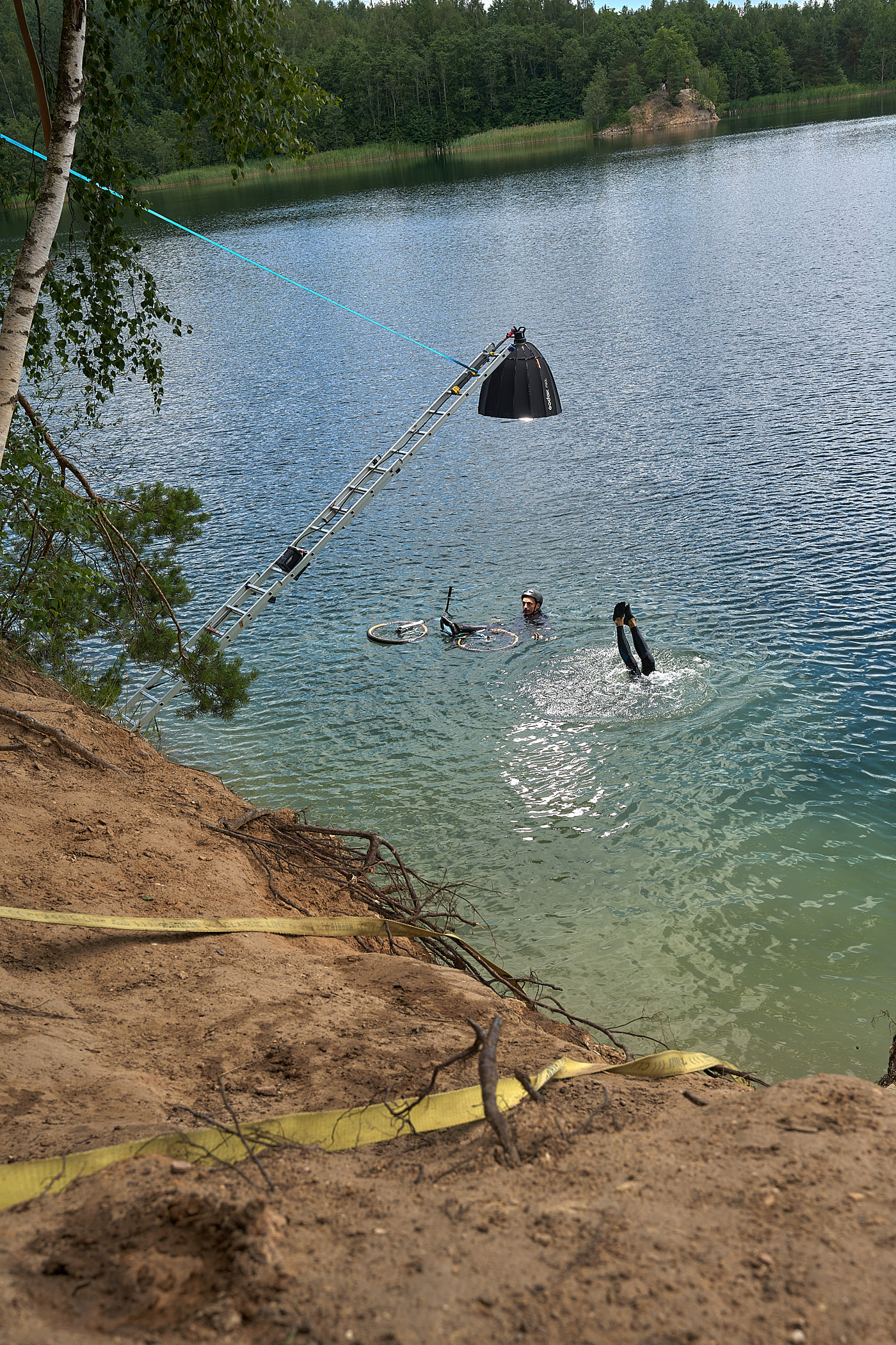A behind-the-scenes photo of how Volodya Voronin captured the BMX in water shot using a ladder, a rope, and a flash
