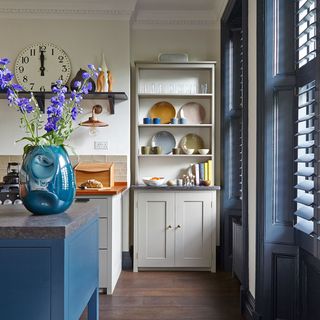kitchen area with blue windows and white cupboard