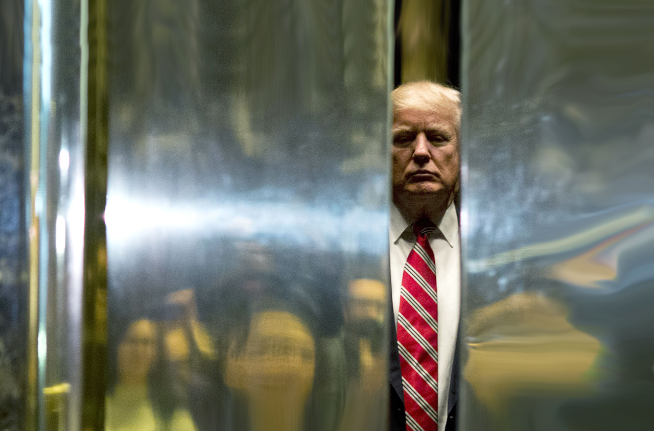 President Trump peeks through some doors.