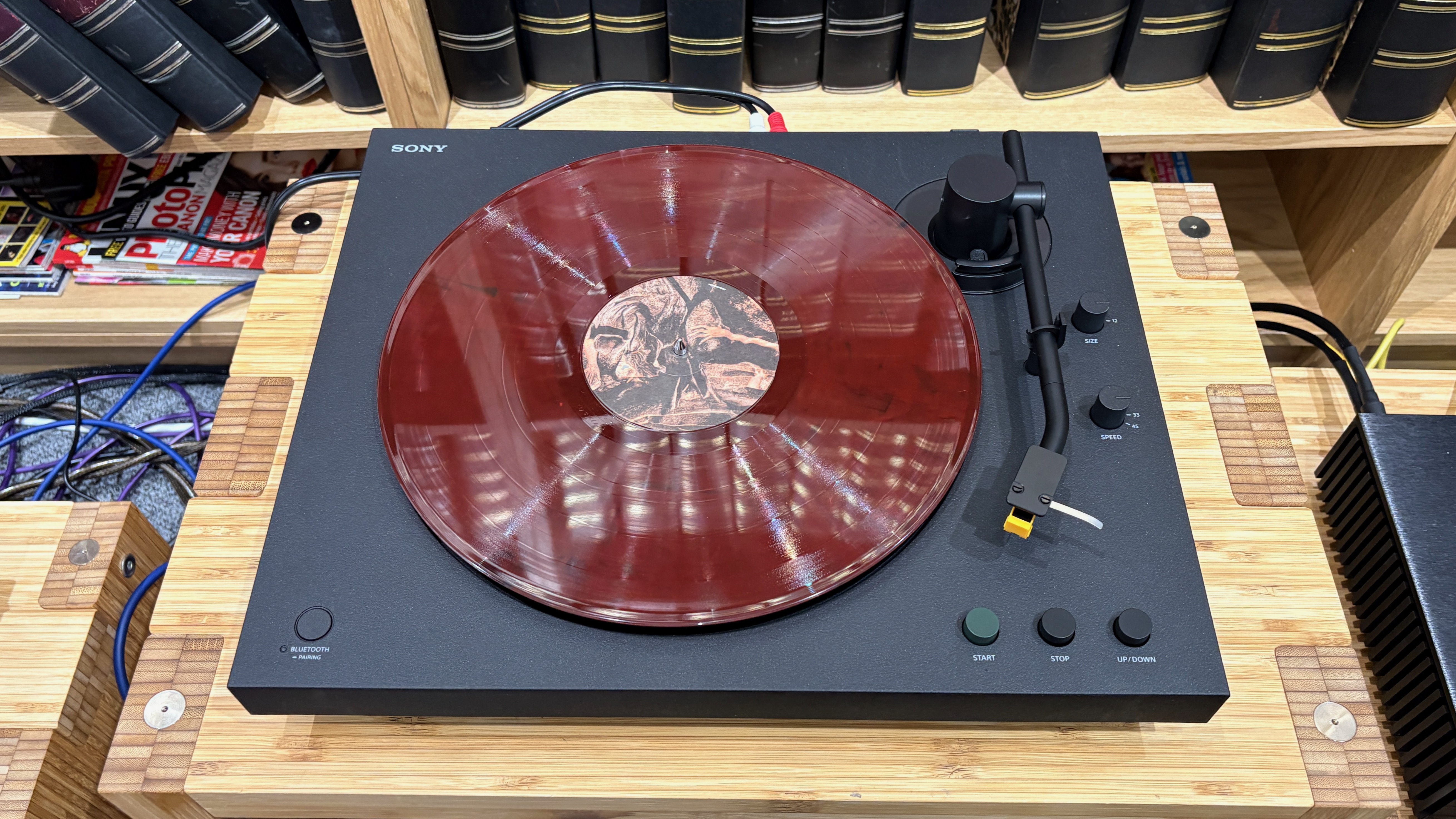 Sony PS-LX5BT turntable on wooden hi-fi rack with red vinyl on platter